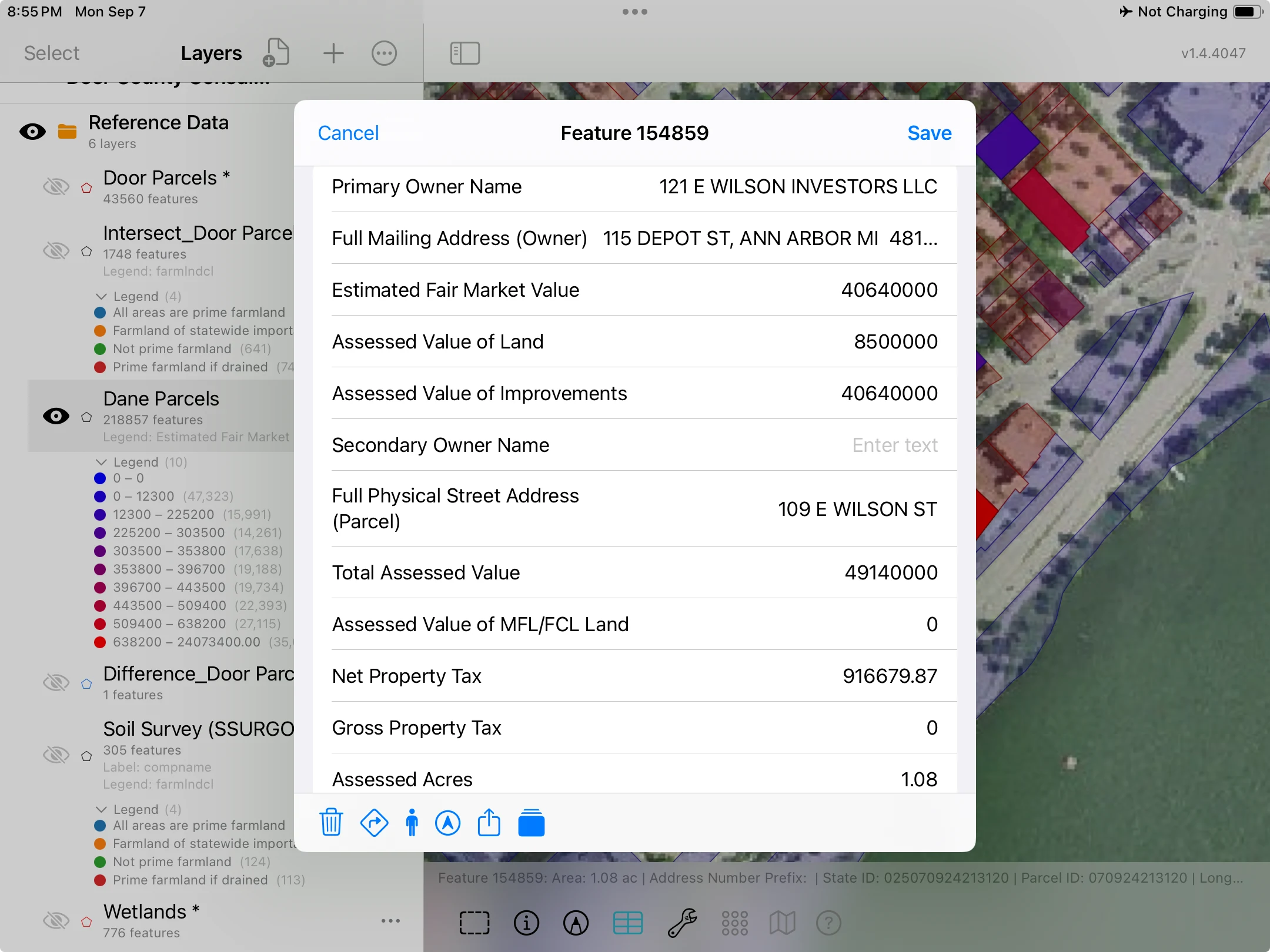 A Madison parcel attribute sheet on iPad showing its address, assessed values and acreage, with styled parcel boundaries behind it.