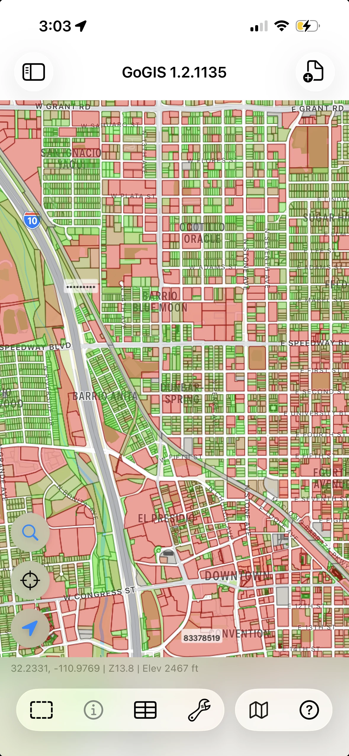 Parcel polygons styled in green and red across an urban street map on iPhone.
